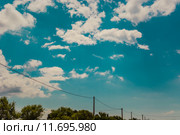 Electric cable above some trees in front of a cloudy sky. Стоковое фото, фотограф Rüdiger Wittmann / PantherMedia / Фотобанк Лори