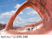 Группа туристов фотографируется под аркой  Корона (Corona Arch) из красного песчаника , США, штат Юта (2015 год). Стоковое фото, фотограф Ирина Кожемякина / Фотобанк Лори