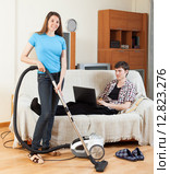 Girl cleaning at home while man with notebook. Стоковое фото, фотограф Яков Филимонов / Фотобанк Лори