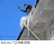 Работник сбивает топором сосульки с крыши (2010 год). Редакционное фото, фотограф lana1501 / Фотобанк Лори