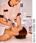 Young woman receiving electric ultrasonic facial massage. Стоковое фото, фотограф Gennadiy Poznyakov / Фотобанк Лори