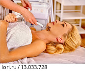 Young woman receiving electric facial massage. Стоковое фото, фотограф Gennadiy Poznyakov / Фотобанк Лори