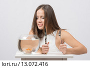 Девушка облизывается и хочет съесть маленькую золотую рыбку. Стоковое фото, фотограф Иванов Алексей / Фотобанк Лори