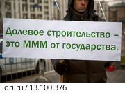 Дольщик строительной компании держит плакат на митинге обманутых дольщиков Московского региона в городе Москве на площади Краснопресненской заставы, Россия (2015 год). Редакционное фото, фотограф Николай Винокуров / Фотобанк Лори