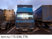 Грузовые автомобили с плакатом против введения платы на федеральных дорогах для грузовых перевозчиков (система "Платон") стоит на стоянке дальнобойщиков в подмосковном городе (2015 год). Редакционное фото, фотограф Николай Винокуров / Фотобанк Лори