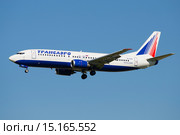 Летящий самолет Boeing 737-400 (EI-CZK) компании Transaero Airlines на фоне голубого неба (2015 год). Редакционное фото, фотограф Виктор Карасев / Фотобанк Лори