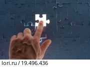 Мужская рука показывает на недостающий кусок головоломки с легким свечением. Стоковое фото, фотограф Кирилл Черезов / Фотобанк Лори