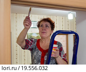 Пожилая женщина подкрашивает дверные проемы. Стоковое фото, фотограф Вячеслав Палес / Фотобанк Лори
