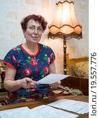 Пожилая женщина просматривает квитанции за коммунальные услуги. Стоковое фото, фотограф Вячеслав Палес / Фотобанк Лори