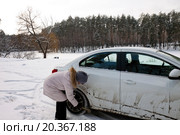 Женщина сметает грязь с машины. Стоковое фото, фотограф Левончук Юрий / Фотобанк Лори
