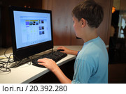 Little boy is surfing internet alone in the room. Стоковое фото, фотограф Losevsky Pavel / Фотобанк Лори