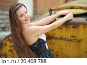 Portrait of beautiful girl who clings to metal container in industrial area. Стоковое фото, фотограф Losevsky Pavel / Фотобанк Лори