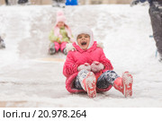 Радостный семилетний ребенок скатывается с ледяной горки. Стоковое фото, фотограф Иванов Алексей / Фотобанк Лори