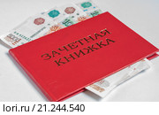 Красная зачетная книжка с вложенными внутрь банкнотами на светлом фоне. Стоковое фото, фотограф Игорь Низов / Фотобанк Лори