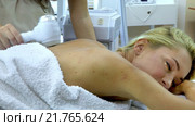 Young woman receiving electric back massage. Стоковое видео, видеограф Gennadiy Poznyakov / Фотобанк Лори