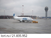 Буксировка самолета Боинг 737-500 (VQ-BJQ) авиакомпании Ютэйр на летное поле. Аэропорт Пулково, Санкт-Петербург (2015 год). Редакционное фото, фотограф Виктор Карасев / Фотобанк Лори