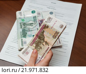 Заработанные деньги в женских руках на фоне трудового договора. Стоковое фото, фотограф Игорь Низов / Фотобанк Лори