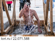 Мужчина крестится во время купания в проруби. Редакционное фото, фотограф Антон Афанасьев / Фотобанк Лори