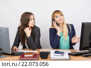 Ситуация в офисе - девушка с недоумением посмотрела на коллегу которая разговаривает по телефону. Стоковое фото, фотограф Иванов Алексей / Фотобанк Лори