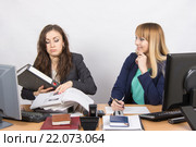 Ситуация в офисе - одна сотрудница завалена работой, другая ничего не делает и смеется глядя на нее. Стоковое фото, фотограф Иванов Алексей / Фотобанк Лори