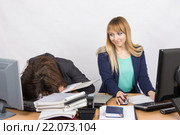 Девушки коллеги в офисе, одна уснула на куче папок, вторая посмотрела на нее. Стоковое фото, фотограф Иванов Алексей / Фотобанк Лори