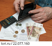 Квитанции на коммуналку. Немолодой мужчина достаёт последние деньги из кошелька на оплату коммунальных услуг (2016 год). Редакционное фото, фотограф Игорь Низов / Фотобанк Лори