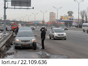 Москва, водитель легкового автомобиля меняет колесо на МКАДе (2016 год). Редакционное фото, фотограф Дмитрий Неумоин / Фотобанк Лори