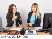 Офисная работница показывает коллеге тушь для ресниц за рабочим столом. Стоковое фото, фотограф Иванов Алексей / Фотобанк Лори