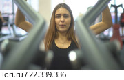 Девушка тренирует мышцы плеч на тренажере. Стоковое видео, видеограф Виктор Аллин / Фотобанк Лори