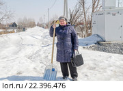 Женщина зимой на даче с лопатой для уборки снега (2015 год). Редакционное фото, фотограф Павел Резниченко / Фотобанк Лори