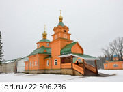 Деревянная оранжевая русская церковь зимой в Свято-Благовещенской Никандровой пустыни в Псковской области. Стоковое фото, фотограф Максим Мицун / Фотобанк Лори