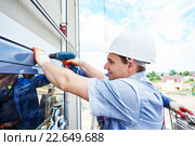 worker builder installing glass windows on facade. Стоковое фото, фотограф Дмитрий Калиновский / Фотобанк Лори