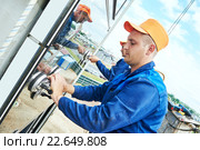builders worker installing glass windows on facade. Стоковое фото, фотограф Дмитрий Калиновский / Фотобанк Лори