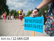 Рука студентки держит табличку "Вечерний факультет" на площади перед ВУЗом. Стоковое фото, фотограф Сайганов Александр / Фотобанк Лори