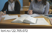Молодая ученица пишет в записной книжке в классе. Стоковое видео, видеограф worker / Фотобанк Лори