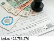 Оплата налогов. Конверт из федеральной налоговой службы, налоговая декларация, деньги и печать предпринимателя. Стоковое фото, фотограф Игорь Низов / Фотобанк Лори