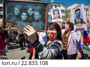 Женщина держит групповой портрет участников Великой Отечественной войны во время акции-шествия "Бессмертный полк" на центральной улице города Керчи в День Победы 9 мая, Республика Крым (2016 год). Редакционное фото, фотограф Николай Винокуров / Фотобанк Лори