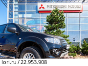 Новый автомобиль Mitsubishi Pajero Sport стоит возле автосалона официального дилера (2016 год). Редакционное фото, фотограф FotograFF / Фотобанк Лори