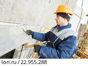 Facade plasterer sealing joint of building wall with putty mastic. Стоковое фото, фотограф Дмитрий Калиновский / Фотобанк Лори