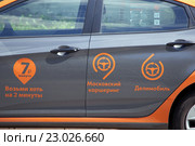 Каршеринг. Логотипы "Московского каршеринга" и сервиса поминутной аренды автомобиля "Делимобиль" на двери автомобиля (2016 год). Редакционное фото, фотограф Александр Замараев / Фотобанк Лори