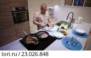 Мужчина отбивает мясо на кухне. Стоковое видео, видеограф Валентин Беспалов / Фотобанк Лори