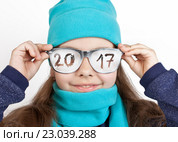 Веселая девочка в шапке и шарфе в смешных очках с надписью "2017" Стоковое фото, фотограф Элина Гаревская / Фотобанк Лори