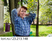 Пожилая женщина повязывает на голову косынку. Стоковое фото, фотограф Вячеслав Палес / Фотобанк Лори