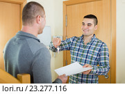 Two men with contract at apartment doorstep. Стоковое фото, фотограф Яков Филимонов / Фотобанк Лори