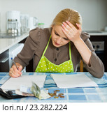 Sad housewife filling payments bills. Стоковое фото, фотограф Яков Филимонов / Фотобанк Лори