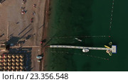 Вид сверху на песчаную часть морского пляжа с морским причалом для катеров и лодок. Пляж Яз (Jaz), Черногория (2016 год). Стоковое видео, видеограф Кекяляйнен Андрей / Фотобанк Лори
