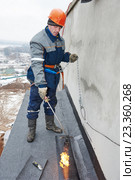 Flat roof installation. Workers melting bitumen roofing felt. Стоковое фото, фотограф Дмитрий Калиновский / Фотобанк Лори