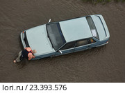 Водитель толкает свою заглохшую машину по затопленной улице. Петрозаводск после сильного ливня 6 августа 2016 года. Редакционное фото, фотограф Сергей Цепек / Фотобанк Лори