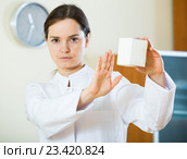 Serious female physician warning of faulty drugs. Стоковое фото, фотограф Яков Филимонов / Фотобанк Лори