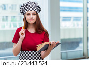 Young housewife referring to recipe book. Стоковое фото, фотограф Elnur / Фотобанк Лори